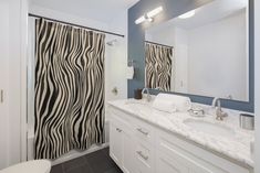 a bathroom with zebra print shower curtain in it