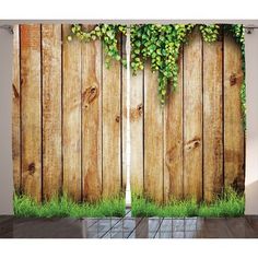 a wooden fence covered in green plants and grass with the top part of it growing up