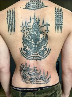 the back of a man with tattoos on his body and an eagle in the center