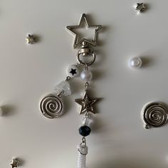 a key chain with stars and beads hanging from it's side on a white surface