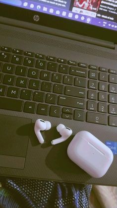 an open laptop computer sitting on top of a table next to headphones and a mouse