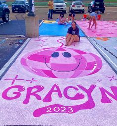 a woman sitting on the ground in front of a sign that says gracyn