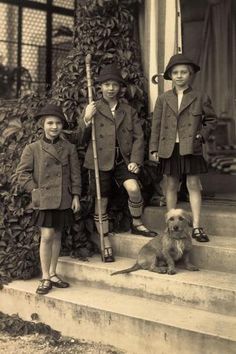 three boys and a dog are standing on the steps