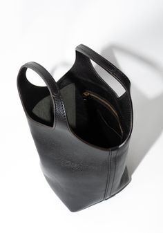 Ama Bag in Black from Lindquist. Small tote bag with hand carry bucket that widens gradually to form an undulating swooped top edge. Features circular handles and an interior drop pocket with zipper and card slot. Made from fully vegetable tanned milled leather is soft and supple, with a natural pebble from the tumbling process. Need a second opinion? If you have special requests or just need advice, please reach out to hello@shop-vestige.com. 100% Vegetable tanned and tumbled milled leather. Ma Small Tote Bag, Hair Sale, Crystal Candles, By Malene Birger, Fall Favorites, Small Tote, Vintage Accessories, Sock Shoes, Sale Design