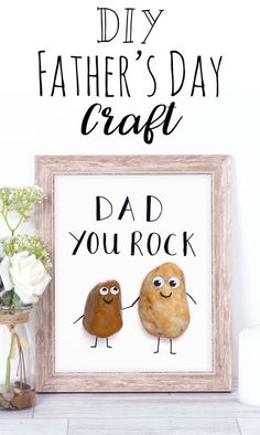 a father's day craft with two rocks and flowers in front of the frame