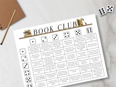 a book club game with dice on the table next to it and two pencils