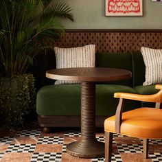 a green couch and table in a room with checkered flooring on the walls