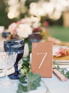 the table is set with plates, glasses and napkins for an elegant wedding reception