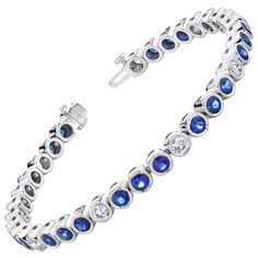 This stylish and elegant tennis bracelet features over 6 carats of blue sapphires and over 2 carats of white diamonds, with each gem showcased in its own 18k white gold bezel. The sapphires have extraordinarily fine color and are beautifully matched, making this bracelet quite a collection of gems! Sparkling round diamonds are the perfect complement to sapphires of this quality - a classic combination, while the bezel setting adds an updated look to a timeless design. The clasp includes a hidden Modern Bracelets, Blue Sapphire Diamond, Tennis Bracelet Diamond, Bezel Diamond, Quality Diamonds, Tennis Bracelet, White Diamonds, Round Brilliant Cut Diamond, Modern Jewelry