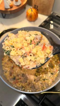 a pan filled with macaroni and cheese on top of a stove burner