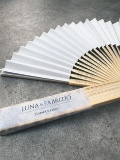 a white and gold fan sitting on top of a cement floor next to a wooden stick