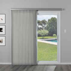 an open sliding door in a room with pictures on the wall and pool behind it