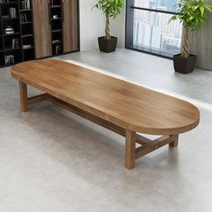 a large wooden table in an office with potted plants on the wall behind it