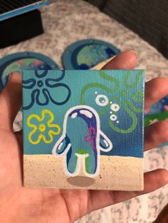 a hand holding up a piece of paper with an octopus on it