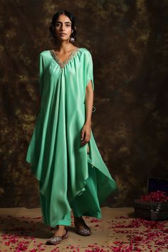 Green kaftan-style kurta with asymmetric hem, tie-up sides and  placement floral motif dabka and zardozi work. Comes with pants.
Components: 2
Fabric: Silk Foil, Crepe
Neckline: V Neck
Color: Green
Embroidered
Kaftan-style
Tassel tie-up
Asymmetric hem
Disclaimer: These are handwoven fabrics and there will be possibility of texture in it - Aza Fashions Asymmetric Kurta, Velvet Kurta, Diwali Outfits, Kaftan Style, Handwoven Fabric, Net Dupatta, Indian Fashion Designers, Kurta With Pants, Green Silk