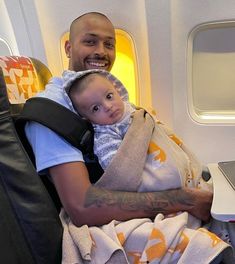 a man holding a baby on an airplane