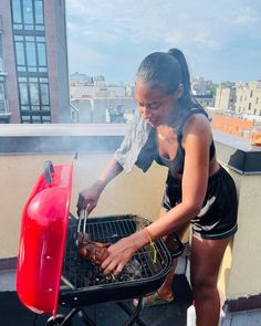 a woman grilling meat on top of a bbq