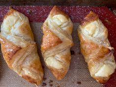 three croissants sitting on top of a baking sheet