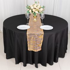 a black table with white plates and flowers on it