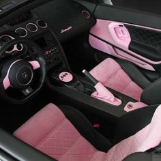 the interior of a pink and black sports car