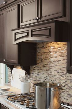 a stove top oven sitting inside of a kitchen next to a pot filled with food