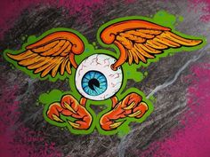 an eye with wings painted on the side of a wall