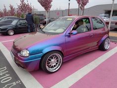 a purple and blue car parked in a parking lot