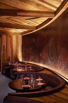 an empty restaurant with wooden booths and wood paneling on the walls, along with place settings for people to eat