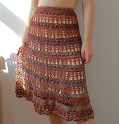 a woman standing in front of a window wearing a skirt with crochet on it