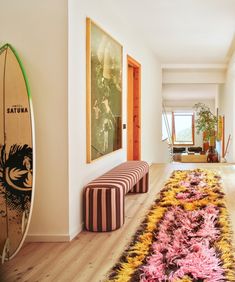 a living room filled with furniture and a surfboard mounted to the side of a wall