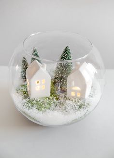 two white houses in a glass bowl with snow on the ground and trees inside it