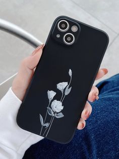 a woman holding up a phone case with flowers on it