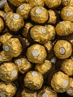 a pile of gold foil wrapped chocolates sitting on top of each other