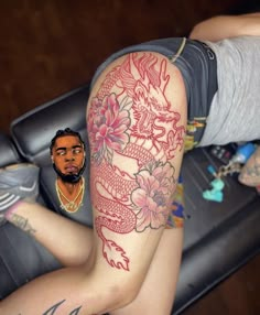 a man with a dragon tattoo on his arm next to a woman's leg