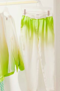 two white and green pants hanging on a rack