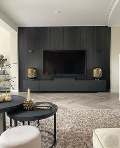 a modern living room with black and white furniture, gold accents and a flat screen tv mounted on the wall