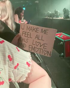 a woman holding a sign that says u make me feel all this love and emotion