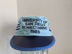 Up for sale is a Vintage University of San Diego Painters Cap. These hats were given out during Homecoming of 1985. It is marked Proudly Made In USA and has a great look to it. These hats are not easy to find! This hat would make an awesome addition to your collection! As far as condition goes, this hat is in Vintage New Old Stock Condition. However, it does show shelf wear consistent with age and storage which can be seen in the pictures provided including creasing to the cardboard bill which i Hat Design Ideas, Show Shelf, University Of San Diego, Dog Patch, Retro Hats, Vintage University, Distressed Hat, Retro Sports, Cap Designs