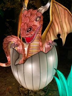 a dragon statue sitting on top of a white ball