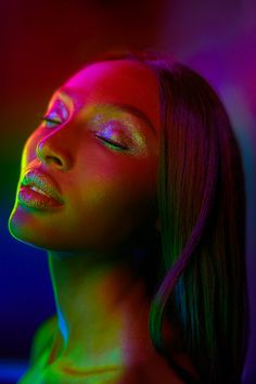 a woman with her eyes closed in neon light