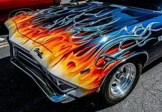 an old car with flames painted on it's hood