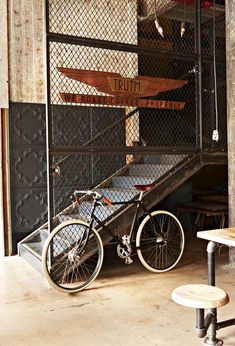 a bicycle parked in front of a metal gate with stairs leading up to the top