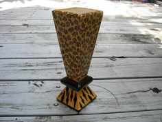 an animal print vase sitting on top of a wooden table