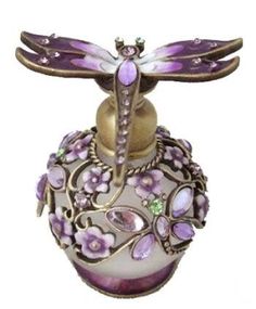 a purple dragon figurine sitting on top of a white vase with pink flowers