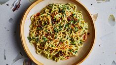 a plate full of pasta with sauce and parmesan cheese on the side, surrounded by confetti