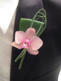 a pink flower is attached to a black suit