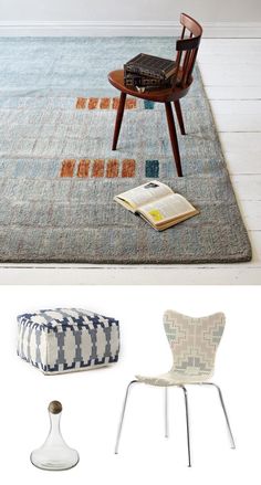 two chairs and a table with books on it in front of a white wall next to a blue rug