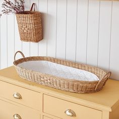 a wicker basket sitting on top of a dresser