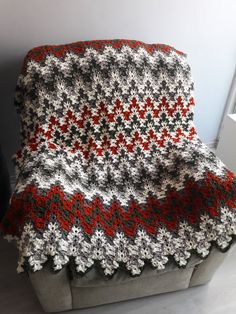 a crocheted blanket sitting on top of a couch