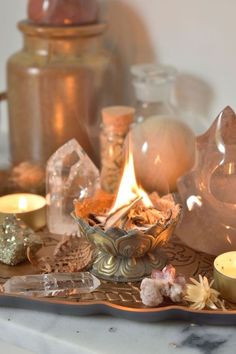 a tray with candles, rocks and other items on it